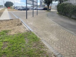 pavers finished in tauranga in a carpark with cars and a billboard