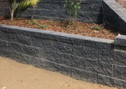 grey stone retaining wall with a garden