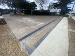 brick pavers laid in tauranga with a billboard in the background and some trees